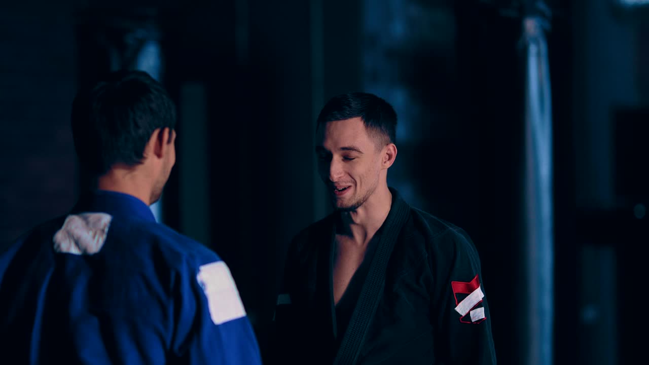 유도 선수들은 서로를 쳐다보고 웃는다. 전투원들의 재미있는 순간. 카메라의 원형 움직임. 초상화.