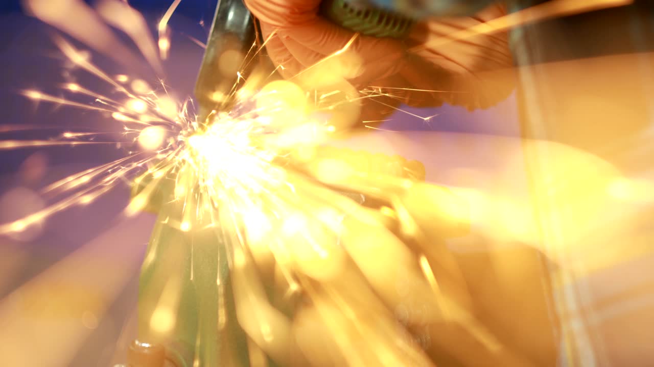 물체는 비스에 여 있습니다. 개진 디스크와 함께 가공 기계를 가진 남자가 많은 불꽃을 고 있습니다.