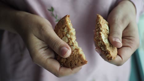 hands holding a broken oatmeal cookie