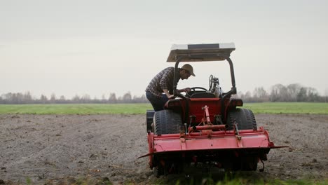 agricultor conduciendo un tractor en un campo