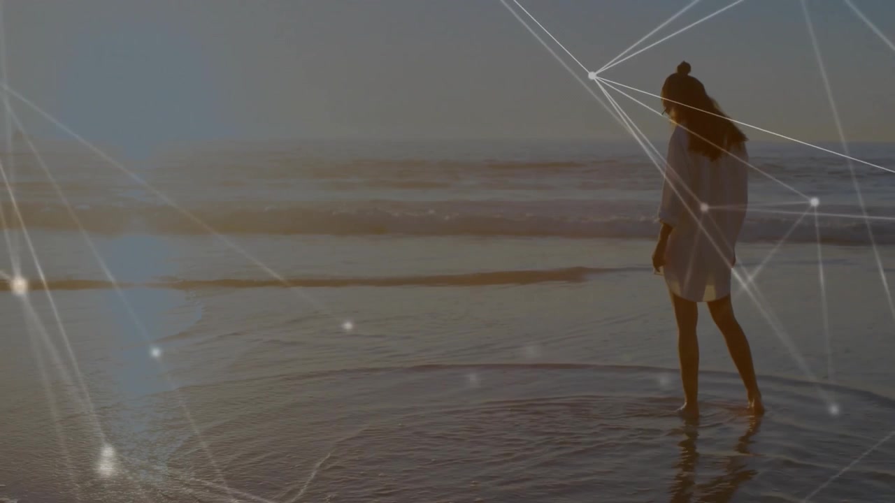 woman stepping into surf and initiating network overlay pulsing in water showing digital connection