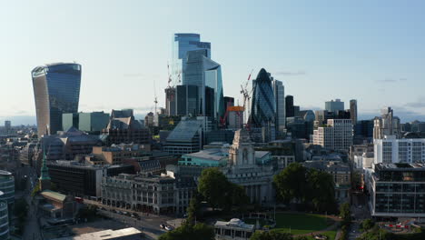 Aerial-footage-of-historic-neoclassical-building-of-luxury-hotel-with-modern-downtown-skyscrapers-in-background.-London,-UK