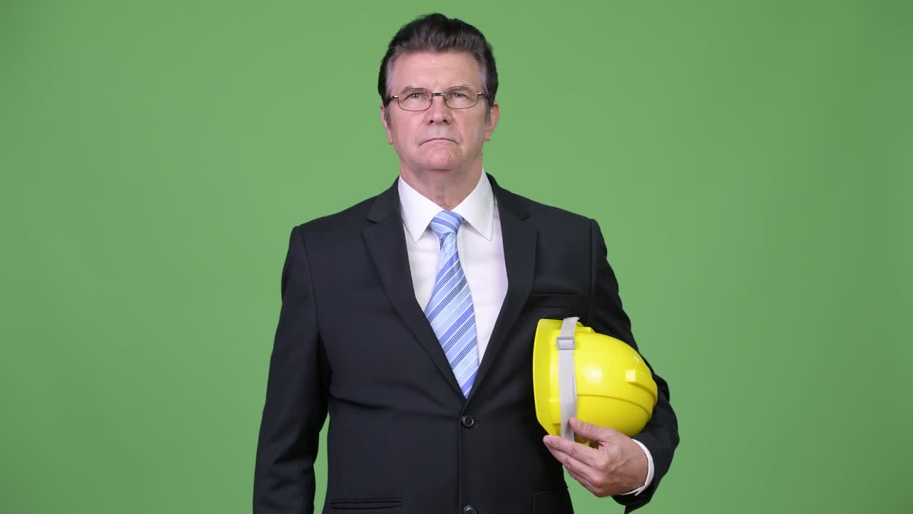 Senior handsome businessman as engineer giving handshake