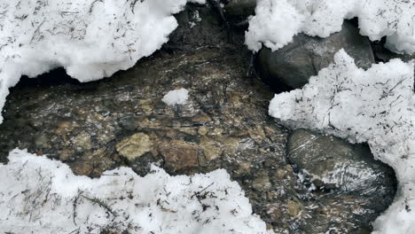 Río-Puro-Bajo-La-Nieve-Del-Invierno.-Corriente-De-Primer-Plano-Flujo-Frío-En-El-Fondo-De-La-Naturaleza.