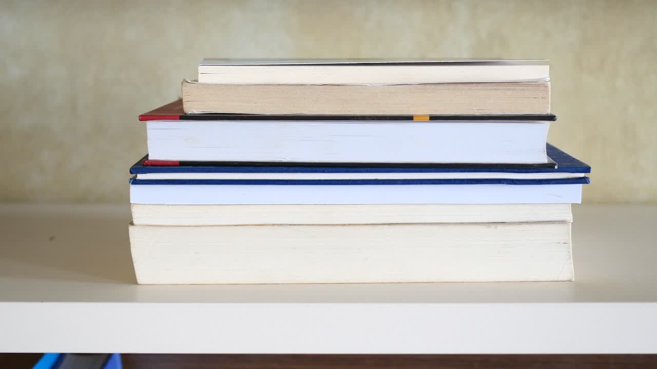A stack of books on a white bookshelf