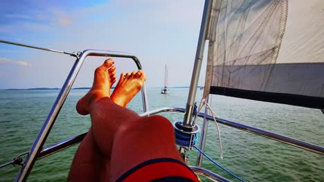 close up shot relaxed traveler man legs on motorboat on beautiful island and mountain carefree concept