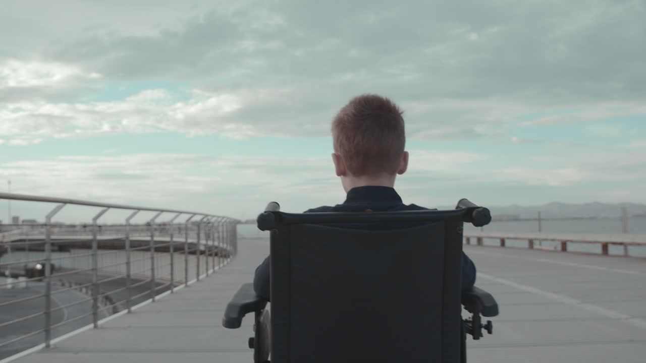 paseo exterior de un niño discapacitado en silla de ruedas eléctrica