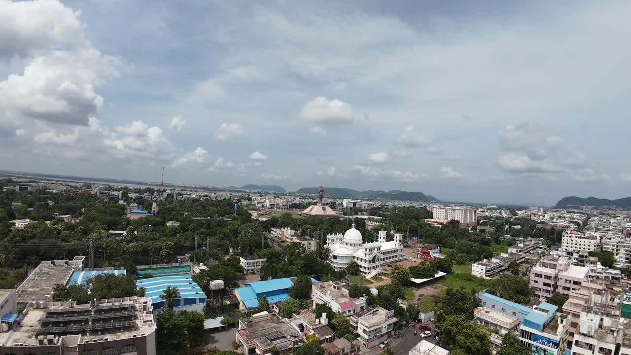 Aerial drone shot of Vijayawada city with statue in the background.