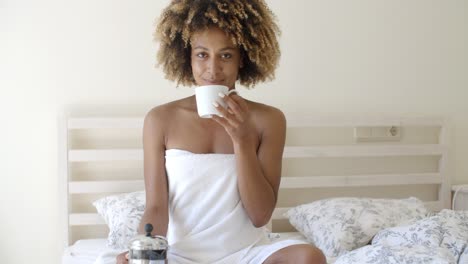 Attractive-Woman-With-A-Cup-Of-Coffee-On-The-Bed