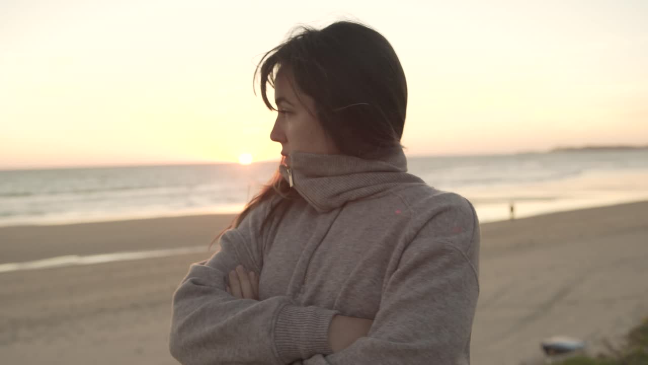 mujer viajando de pie en la playa al atardecer