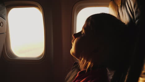 sleep anywhere and in any position a little girl is sleeping in an armchair aboard an airplane morni