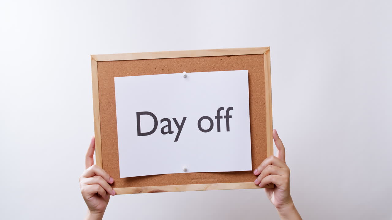 여성의 손은 복사 공간이 있는 흰색 스튜디오 배경에서 쉬는 날이라는 단어가 있는 보드에 있는 종이를 보여줍니다.