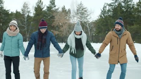 friends ice skating in winter park