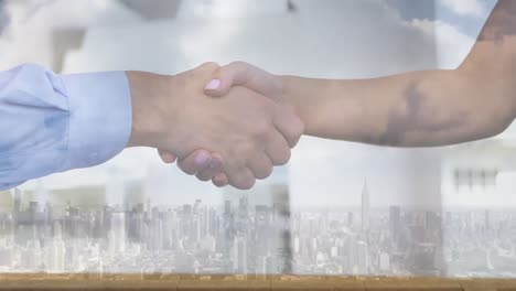 mid section of businessman and businesswoman shaking hands over cityscape against clouds in the sky