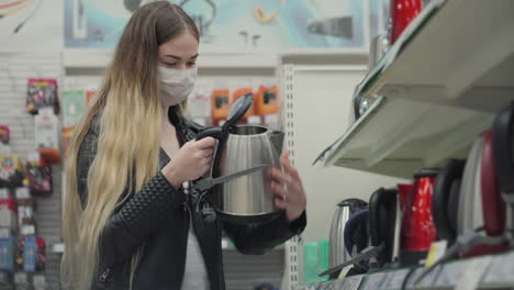 woman shopping for an electric kettle in a store