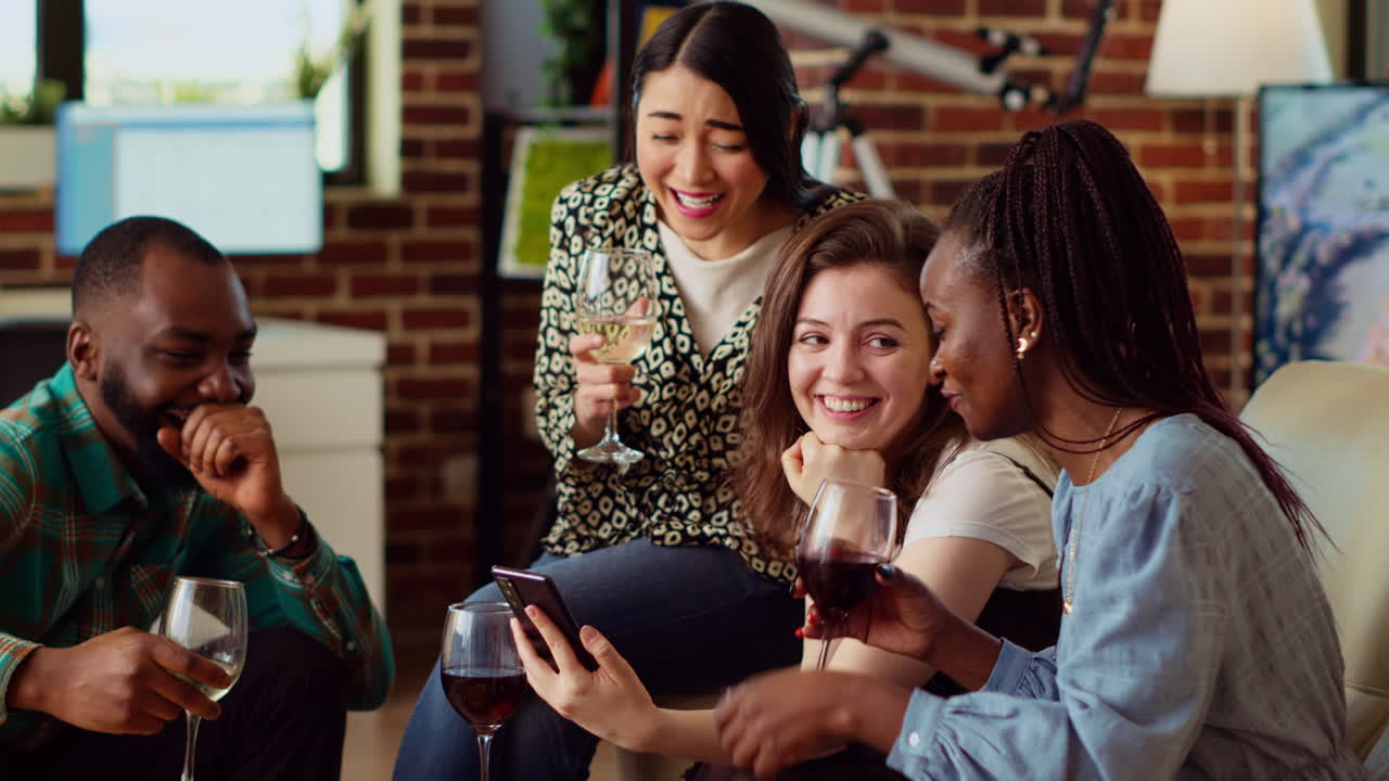 Amused guests in living room gossiping about cringe images posted online by mate