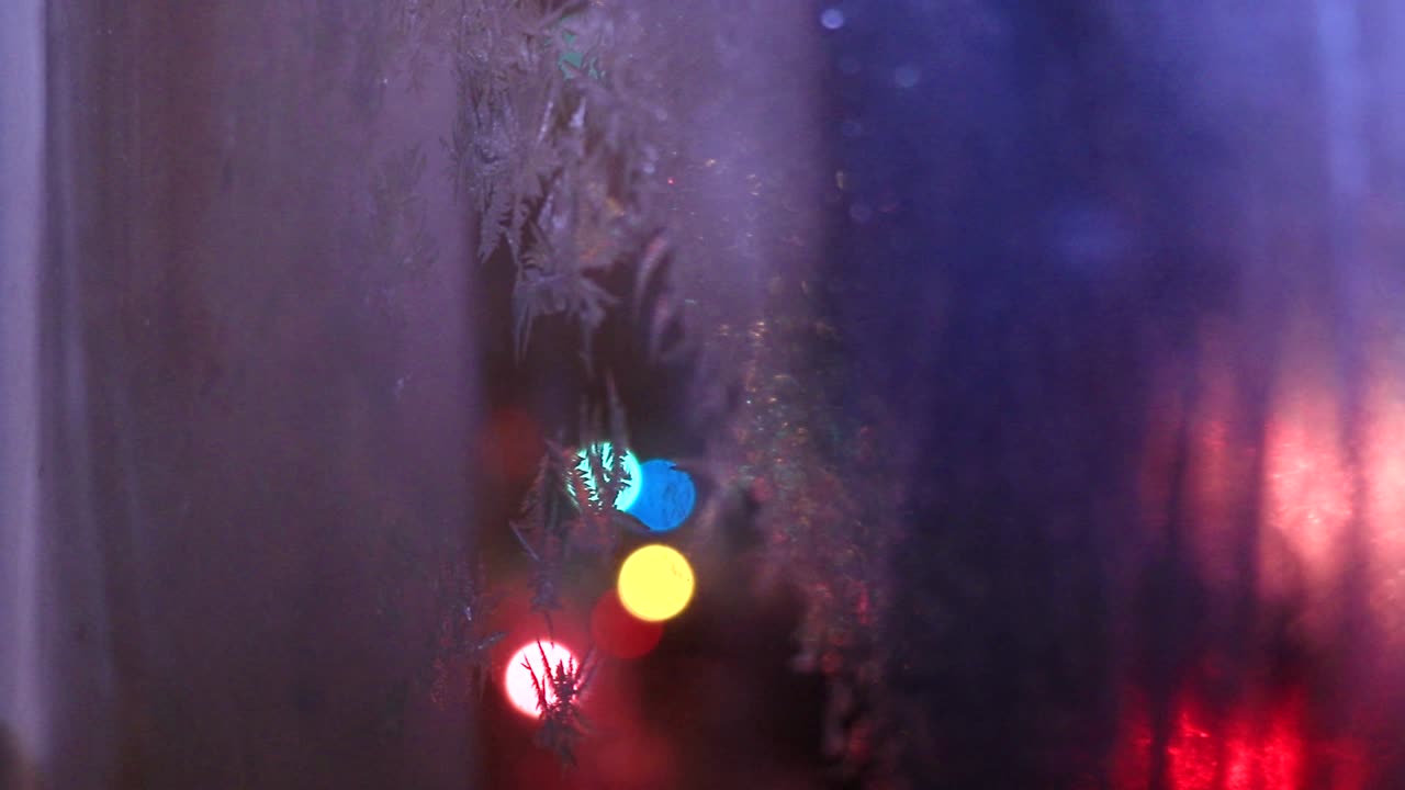 una ventana de casa helada durante una noche fría de invierno