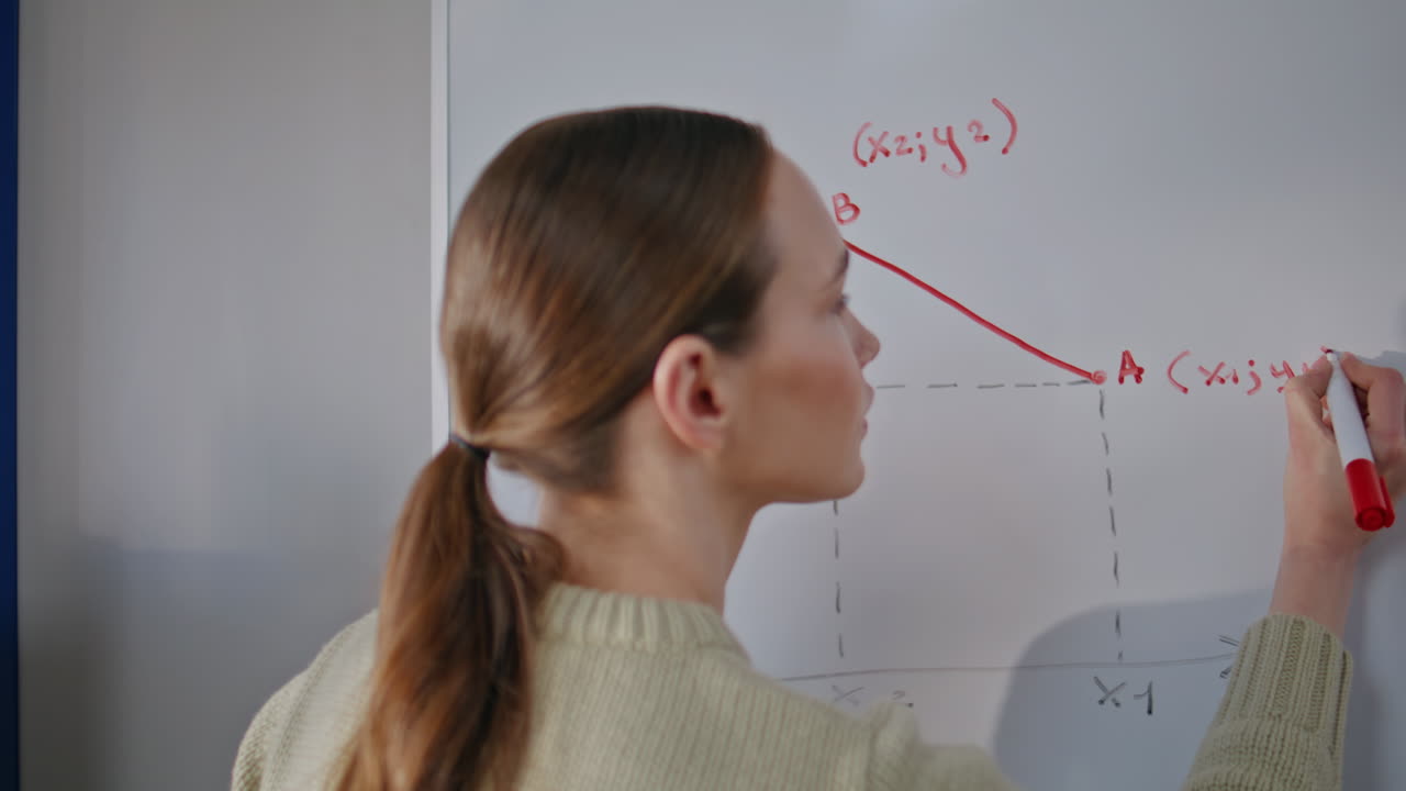 Strict professor drawing diagram at whiteboard closeup. Teacher solving equation
