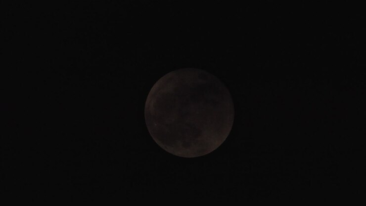 Black Clouds Passing In Front Of The Moon In The Dark Sky