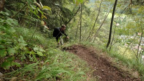 a man walking through a very green forest on an overcast day in slovenia located near the village of gozd martuljek