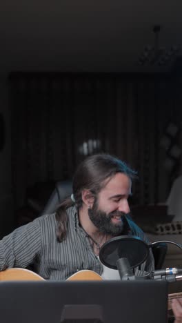 musician singing and playing guitar in a recording studio