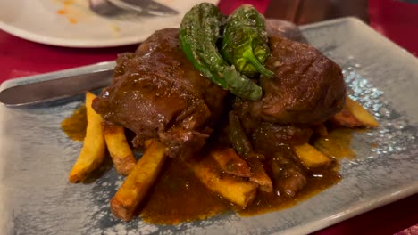 Estofado-Tradicional-De-Rabo-De-Toro-Español-Con-Patatas-Fritas,-Carne-Cocida-A-Fuego-Lento-En-Salsa-De-Vino-Tinto-En-Málaga,-España,-Comida-Sabrosa,-Toma-De-4k