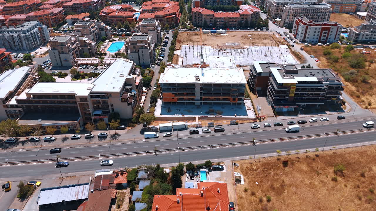 Varna, Bulgaria, 29. juni 2025: Luftfoto av tett feriestedutvikling langs en vei. Scenen viser flere ferdigstilte leilighetsbygg og en byggeplass nær hovedgaten.