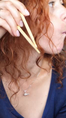 una mujer comiendo sushi.