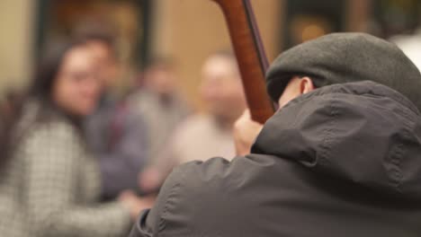 foto de trás do artista de rua tocando chelo