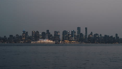 Pájaros-Volando-Sobre-El-Horizonte-Del-Centro-De-Vancouver-Por-La-Noche