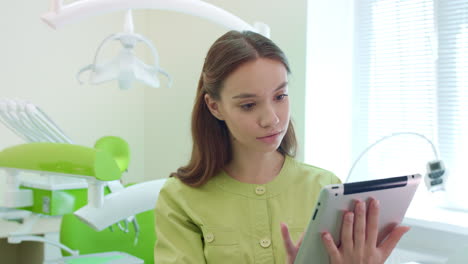 female dentist working on tablet in dental office