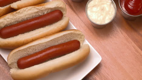 Appetitlicher-Teller-Mit-Hot-Dogs-Mit-Einer-Auswahl-An-Saucen-An-Der-Seite