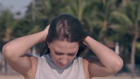 brunette with loose long hair poses on beach slow motion