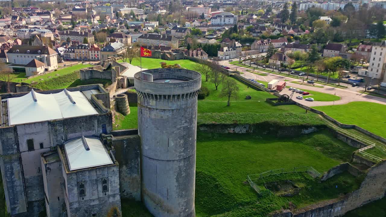 Stone tower of historic Château de Falaise, William the Conqueror's castle, Normandy, France, town in background. Aerial backward