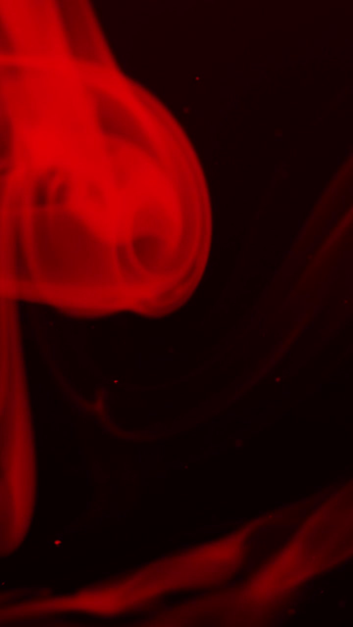 Fumo rosso atmosferico e particelle su sfondo nero