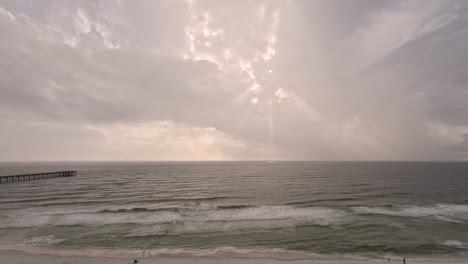 Wolken,-Wellen-Und-Gelegentliches-Sonnenlicht,-Das-Im-Zeitraffer-Eines-Strandes-Am-Meer-Durchscheint