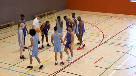 basketball team huddling on court, coach motivating players before game