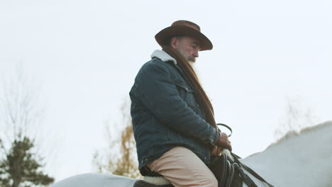 man putting the saddle on the horse