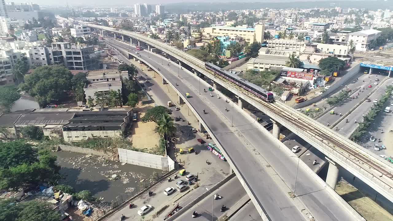 panorámica aérea a la izquierda del tráfico de chikmagalur en un día soleado, india