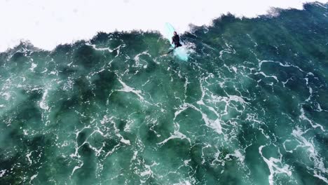 surfer paddling through waves in carlsbad