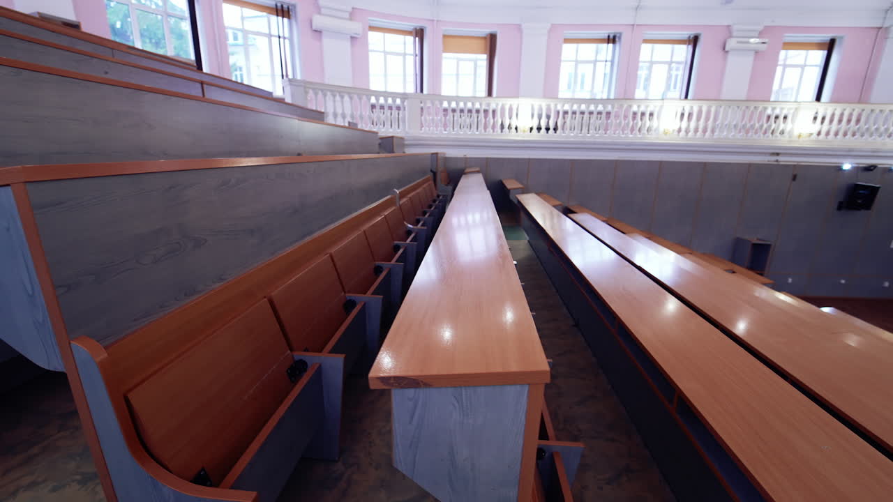 Inside university lecture hall with nobody inside. Interior of big auditorium.