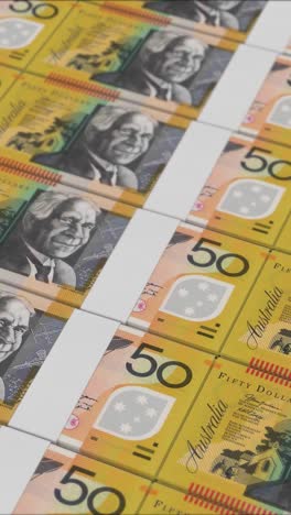 vídeo vertical de billetes de 50 dólares australianos impresos por una prensa de dinero