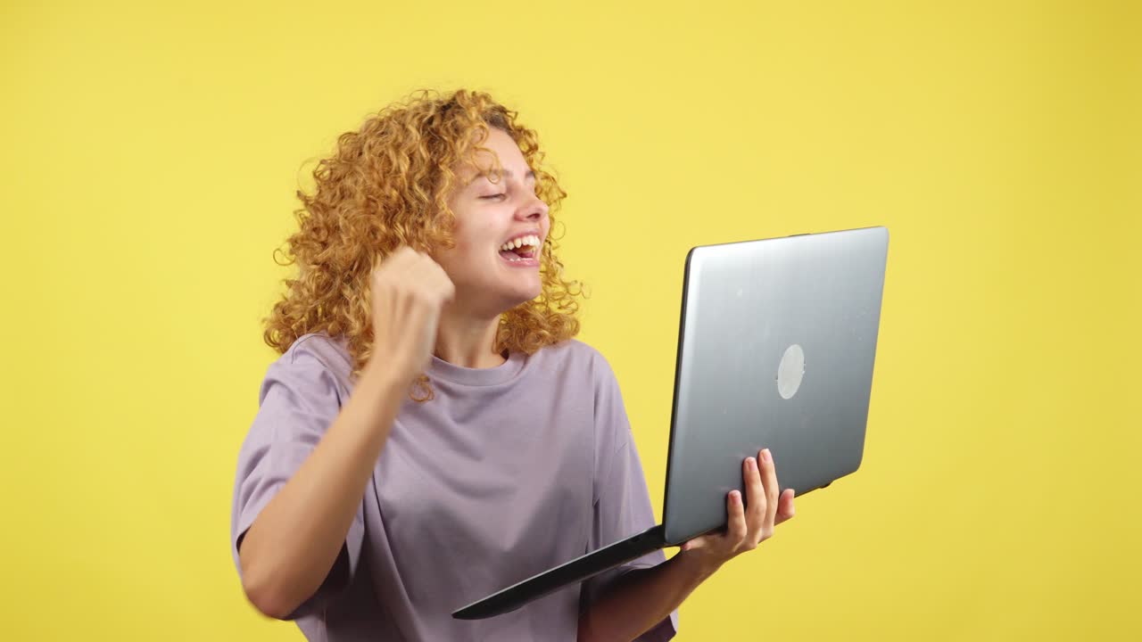 Excited woman celebrating success with her laptop