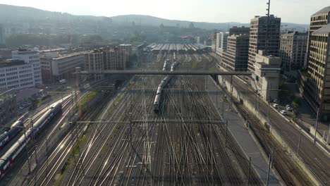 High-Aerial-View-of-Train-Departing-Central-Station-in-Zurich,-Switzerland-on-Summer-Day