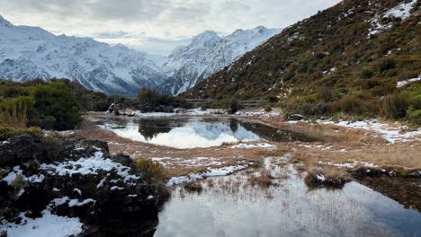 capa ligera de nieve en estanques alpinos: toma fija de los alpes del sur de nueva zelanda