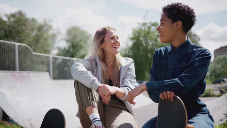 two female friends talking and laughing in urban skate park