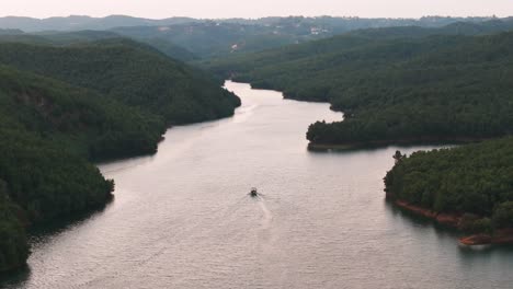 Small-tourist-boat-float-on-river-through-tropic-mountain-valley,-Albania