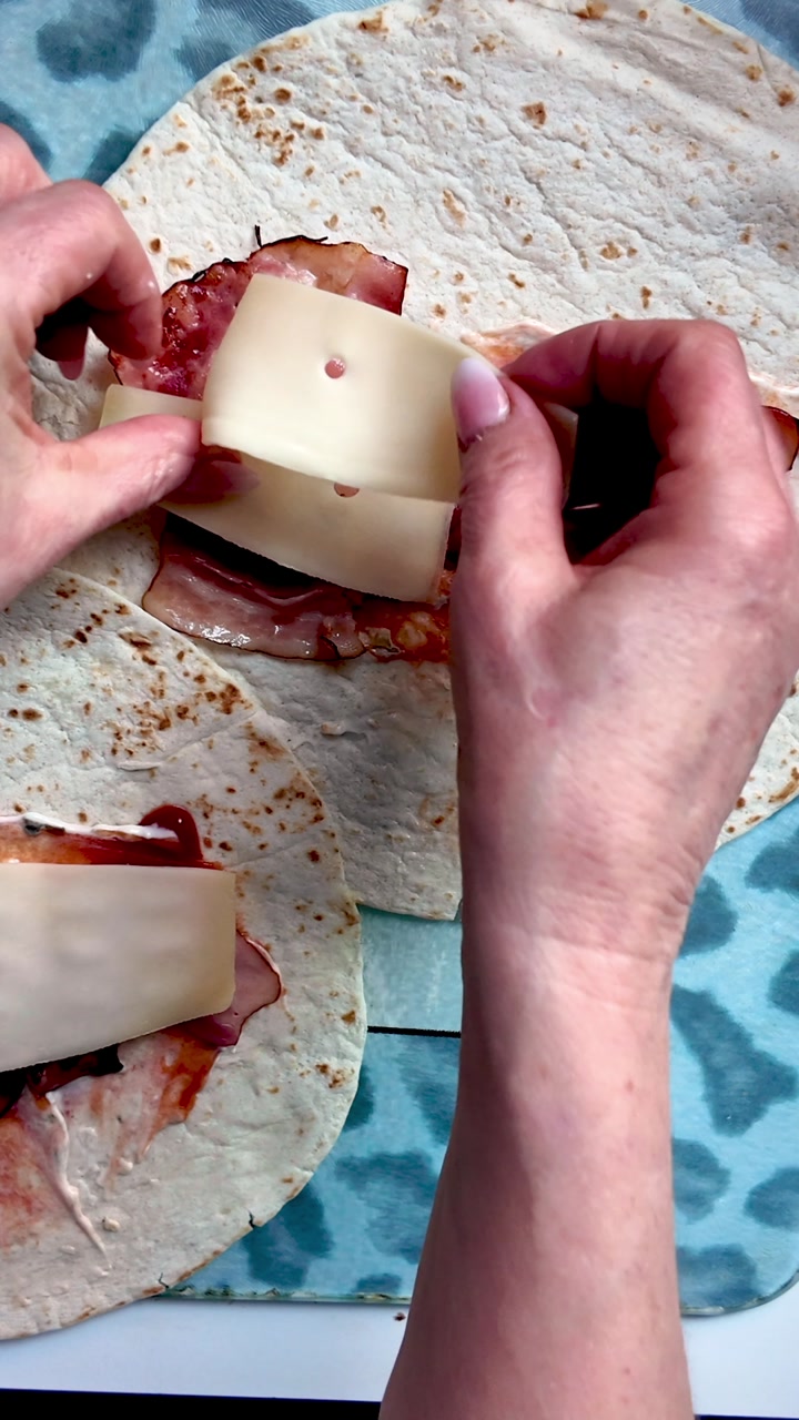 Filling Tortilla wrap with cheese and meat for quick tasty comfort food snack