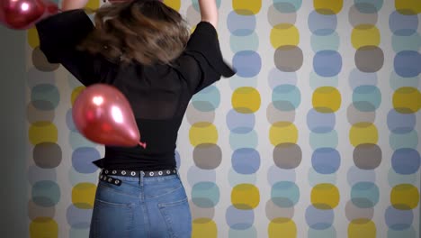 Mujer-Joven-Bailando-Frente-A-Globos-Flotantes-En-El-Aire-Contra-Un-Fondo-Colorido