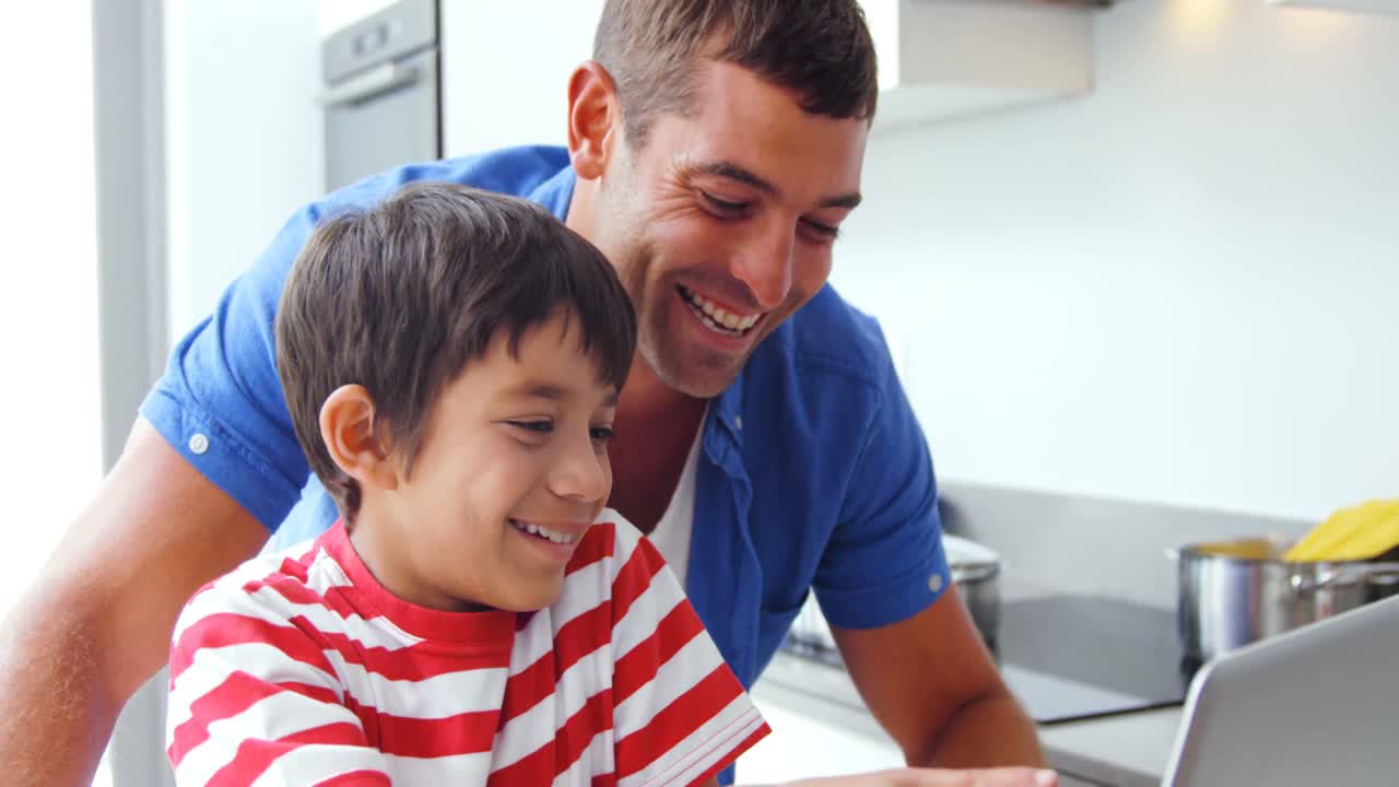 padre e hijo usando computadora portátil
